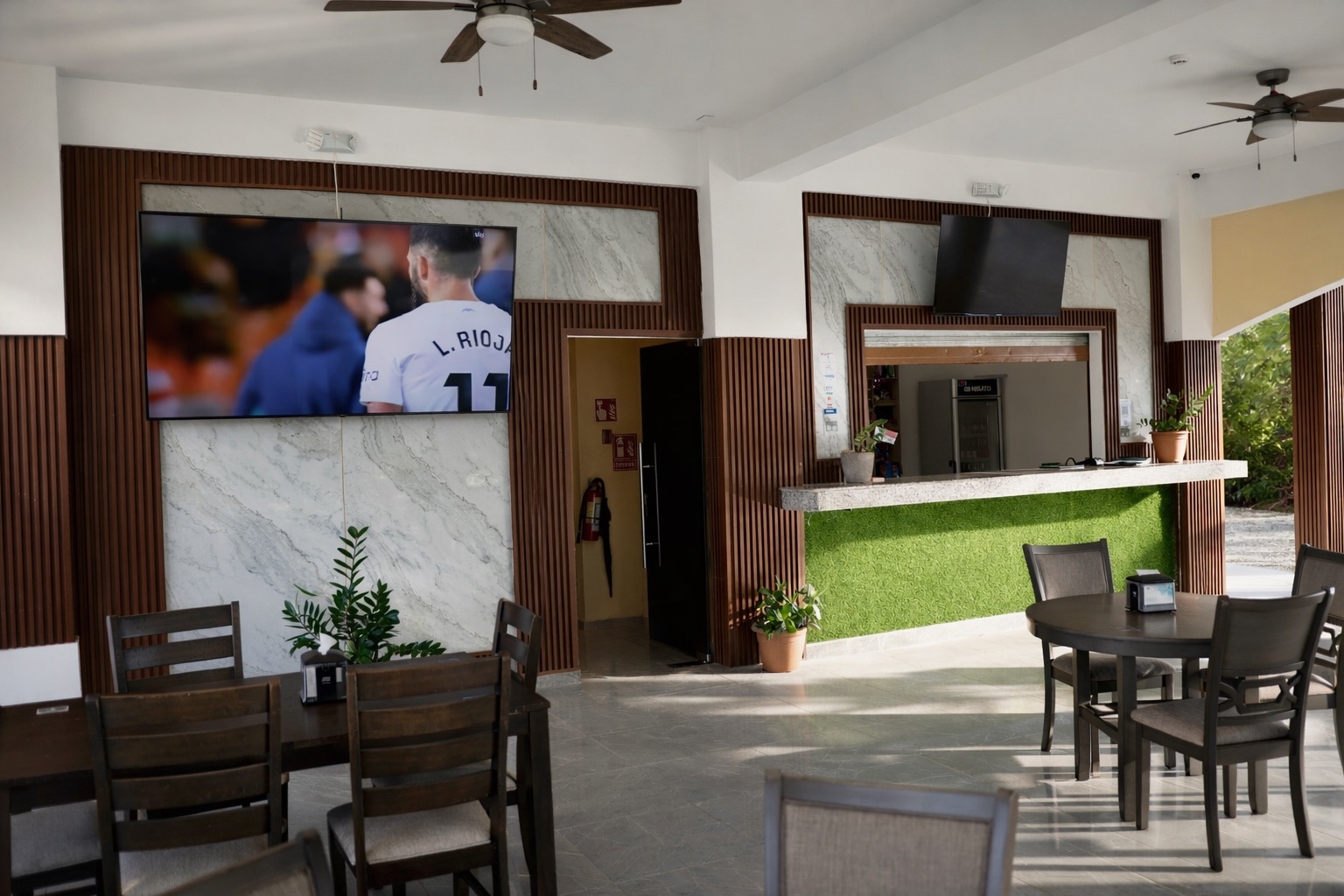 Interior del Restaurante Mely con pantallas y barra